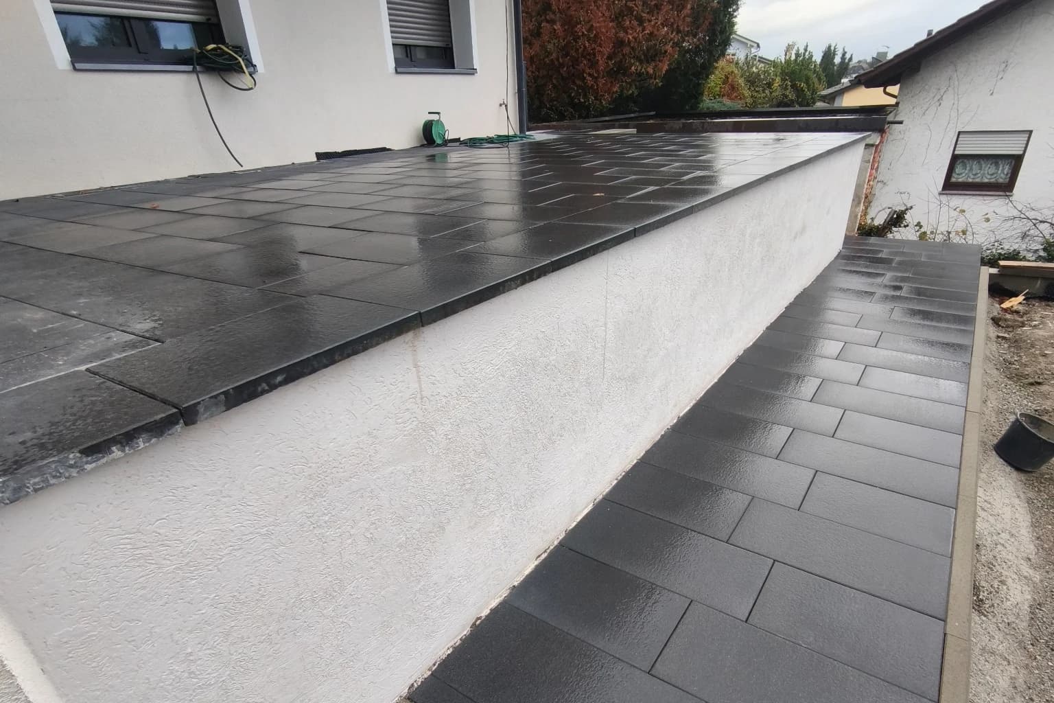 Terrassenfläche und befestigter Weg entlang des Hauses