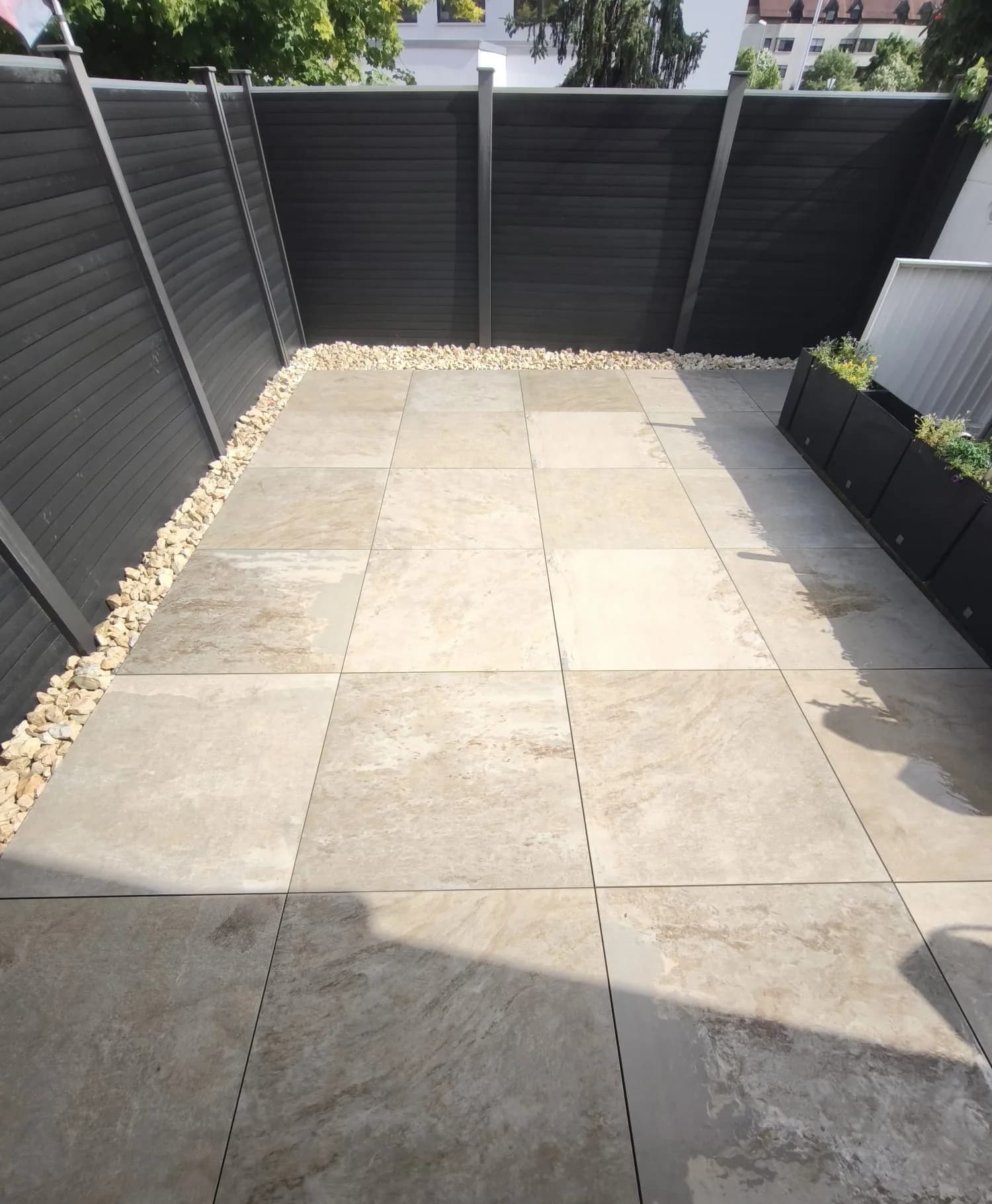 Fertige Terrassenfläche mit großformatigen Platten in einem Innenhof